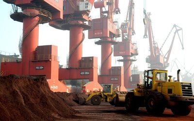 FILE PHOTO: Workers transport soil containing rare earth elements for export at a port in Lianyungang