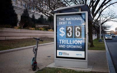A poster displays at a bus shelter the current U.S. National debt at 36 Trillion dollars in Washington