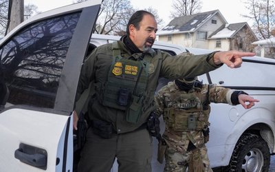 Border Patrol agents point out of a car as protesters tried blocking the path of a vehicle after a driver was shot by a U.S. immigration agent, according to local and federal officials, in Minneapolis