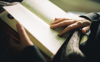 Woman reading a book, indoor light, hands close-up