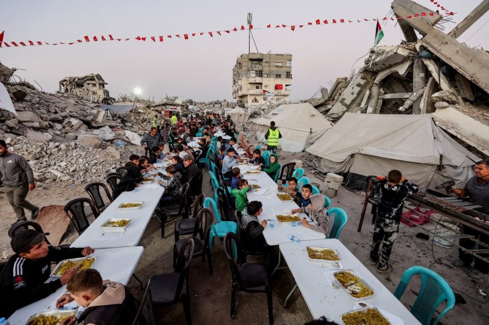 Palestinians gather to break their fast by eating Iftar meals on the first day of the holy month of Ramadan, in Gaza City