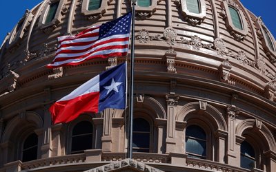 The U.S flag and the Texas State flag fly over the Texas State Capitol as the state senate debates the #SB6 bathroom bill in Austin