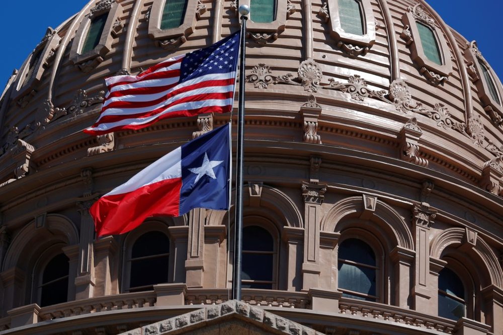 The U.S flag and the Texas State flag fly over the Texas State Capitol as the state senate debates the #SB6 bathroom bill in Austin