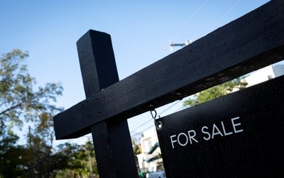 A "For Sale" sign stands at a house in Miami