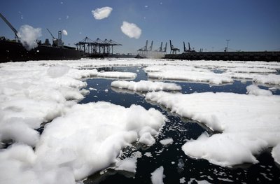 Foam swirls in the harbor as firefighters douse a smouldering dock fire that broke out on Monday evening and burned about 150 feet (45 meters) of a wharf area at the Port of Los Angeles