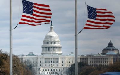 American flags fly with U.S. Capitol on background