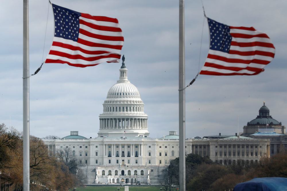 American flags fly with U.S. Capitol on background
