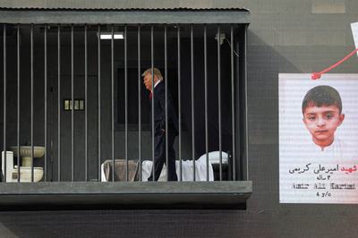 Person dressed up as US President Donald Trump performs inside mock prison cell in Tehran