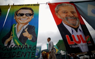 FILE PHOTO: A man walks past presidential campaign materials depicting Brazil's former President Luiz Inacio Lula da Silva and and President Jair Bolsonaro in Brasilia