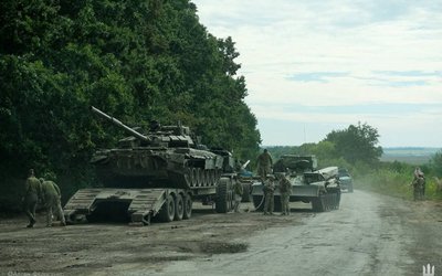Ukrainian service members prepare to transport a Russian tank captured during a counteroffensive operation in Kharkiv region