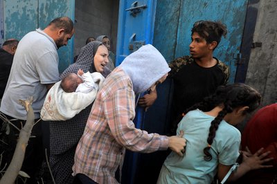 Palestinians evacuate the site of Israeli strikes on houses in Maghazi refugee camp