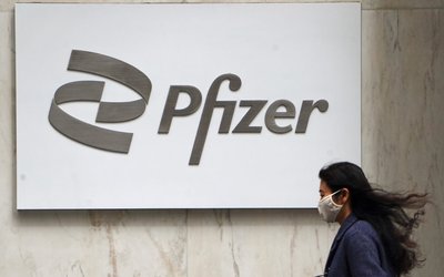 FILE PHOTO: A person walks past a Pfizer logo in New York City