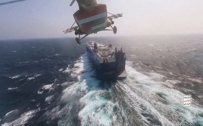 FILE PHOTO: Houthi military helicopter over the Galaxy Leader cargo ship in the Red Sea