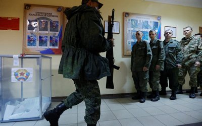 Service members of the self-proclaimed Luhansk People's Republic vote during a referendum in Luhansk